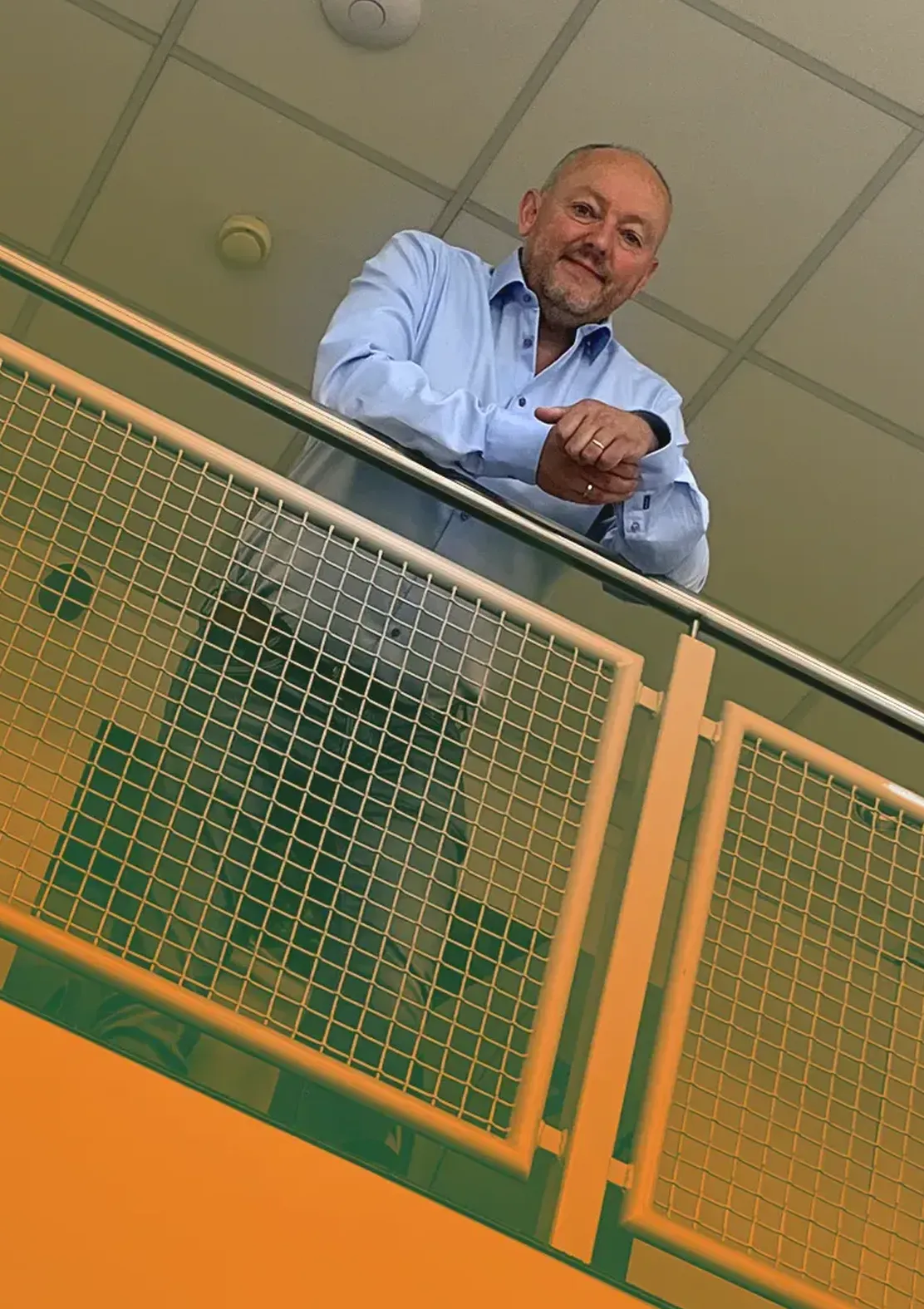 Foto toont Henri staand bovenaan de trap.